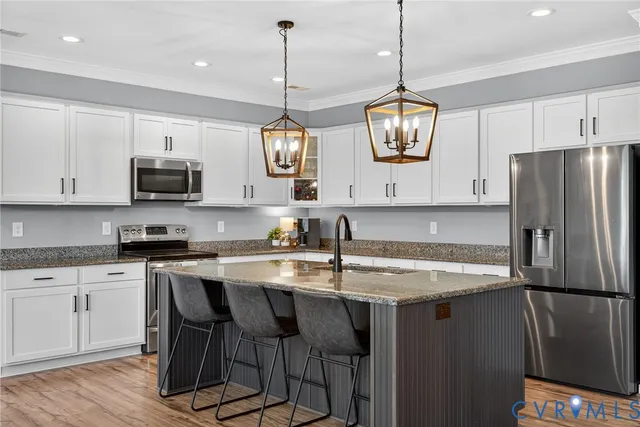 a kitchen with stainless steel appliances granite countertop a refrigerator a stove a sink and a microwave