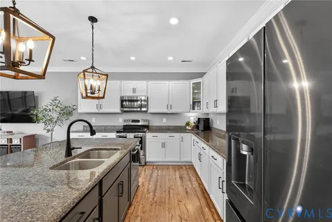 a kitchen with stainless steel appliances granite countertop a sink a stove and refrigerator