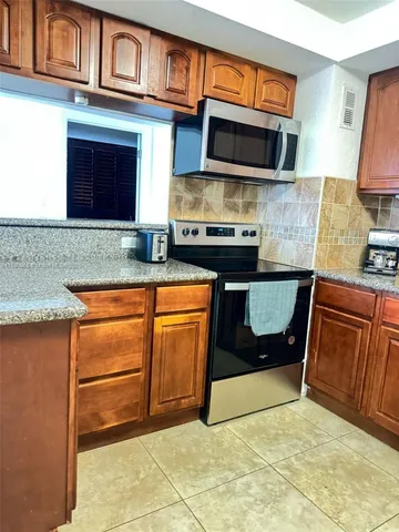 a kitchen with granite countertop a stove and a sink