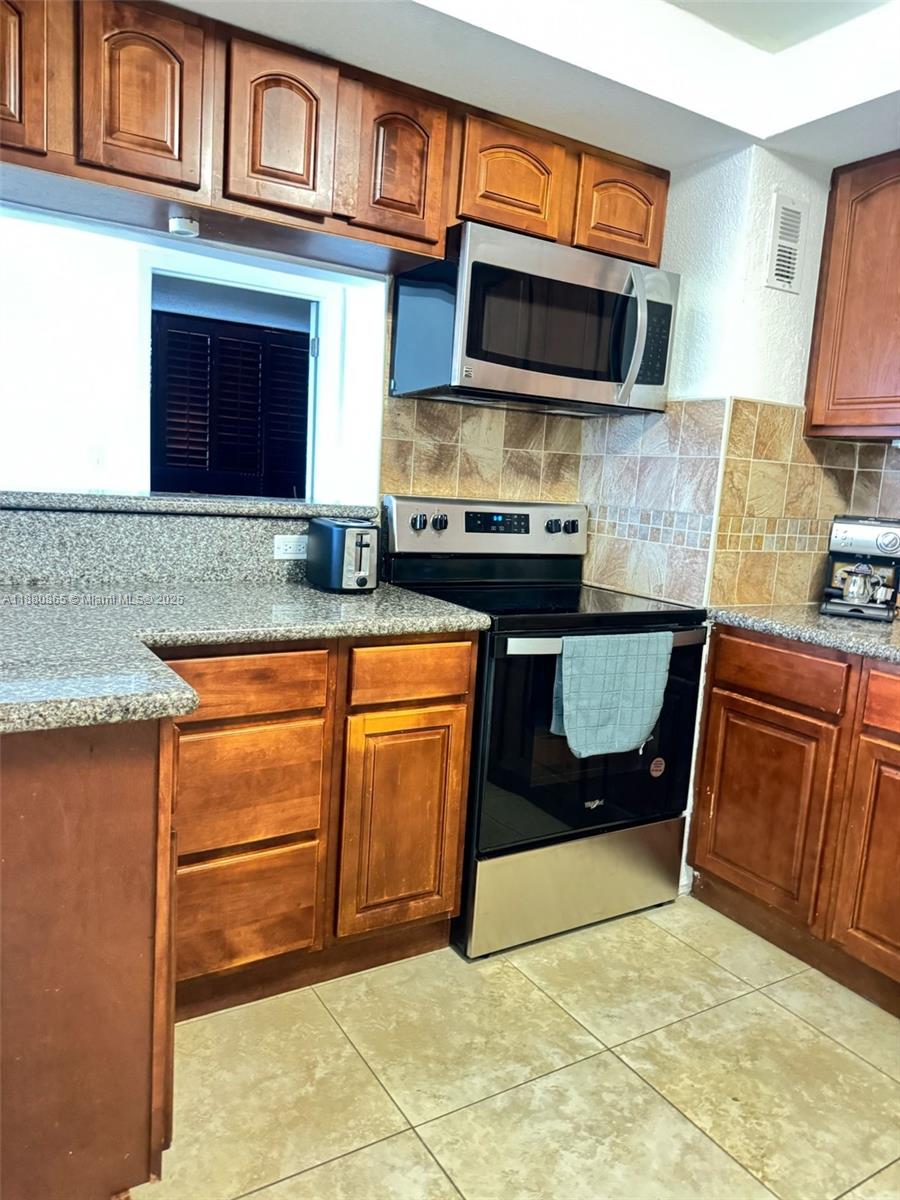 5838 Collins Avenue, Unit 2A Miami Beach, FL 33140 - Photo 4 of 14 a kitchen with granite countertop a stove and a sink