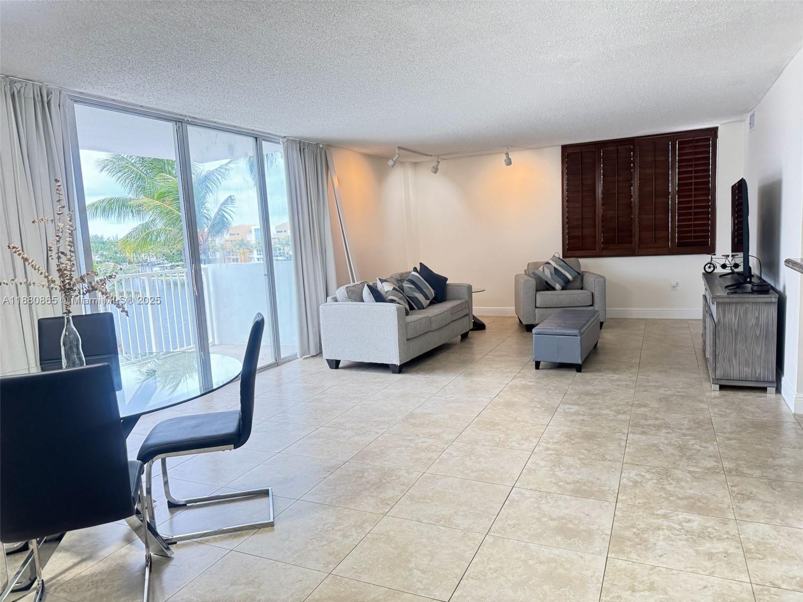 5838 Collins Avenue, Unit 2A Miami Beach, FL 33140 - Photo 5 of 14 a living room with furniture and a flat screen tv