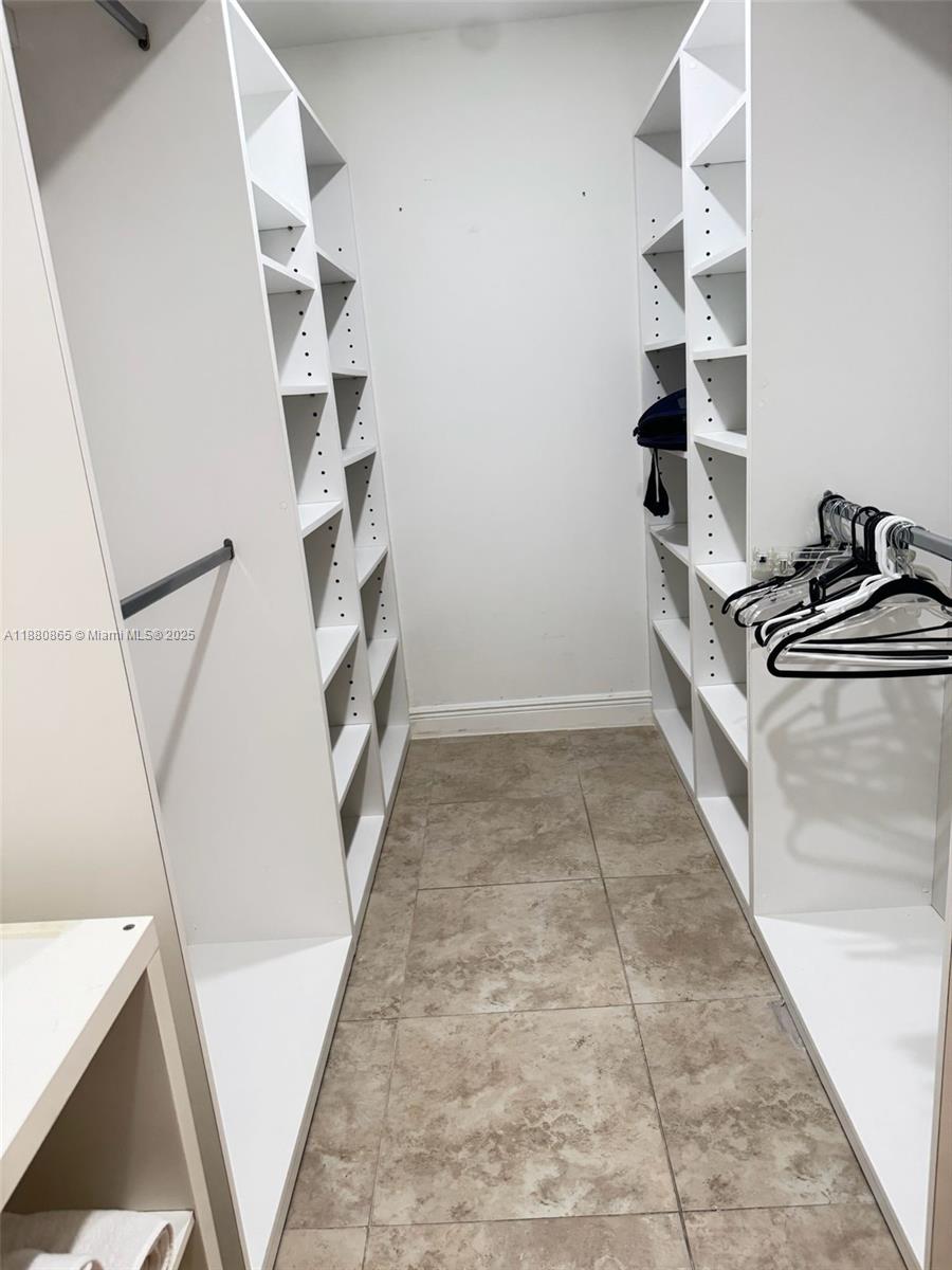 5838 Collins Avenue, Unit 2A Miami Beach, FL 33140 - Photo 9 of 14 a view of an empty walk in closet with empty racks