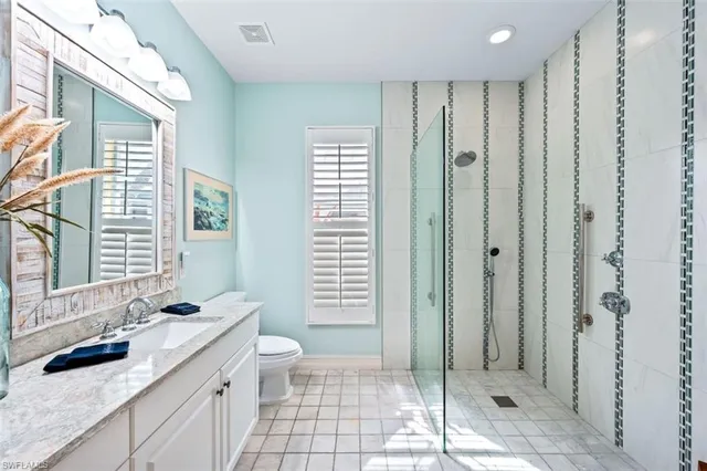 a bathroom with a double vanity sink toilet and shower