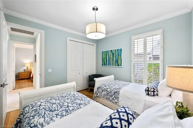 a bedroom with two beds and a chandelier