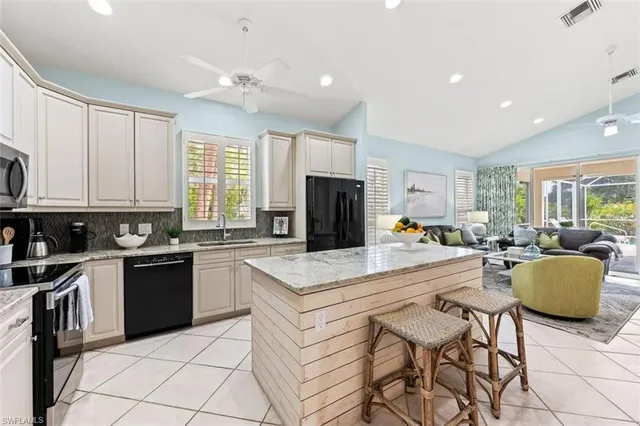 a kitchen with stainless steel appliances kitchen island granite countertop a stove top oven a sink dishwasher and a refrigerator