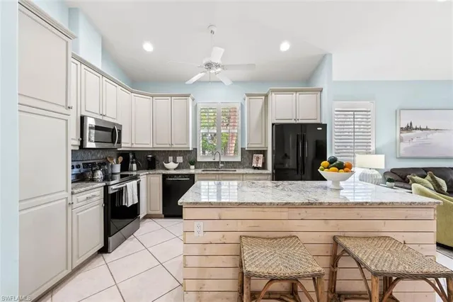 a kitchen with stainless steel appliances granite countertop a stove top oven a sink dishwasher and white cabinets