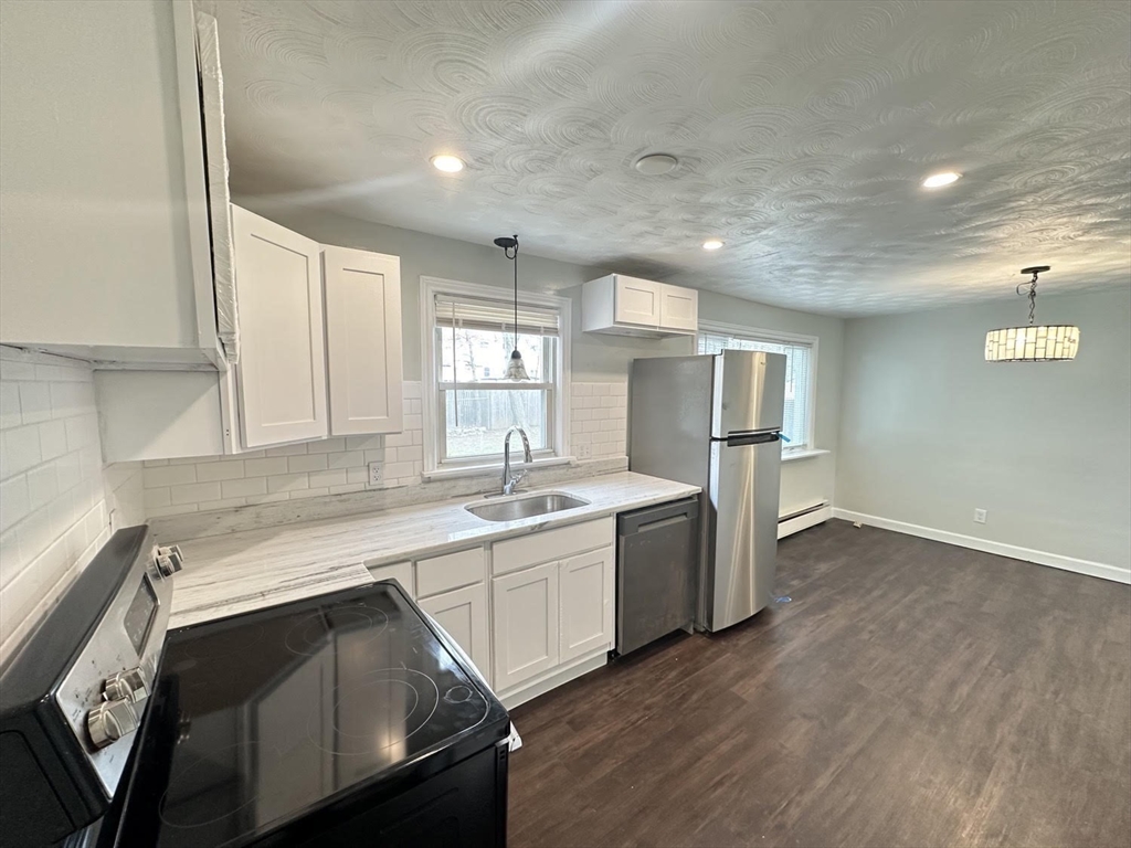 38 Hadley Street Springfield, MA 01118 - Photo 3 of 20 a kitchen with stainless steel appliances granite countertop a sink a stove a refrigerator and island with wooden floor