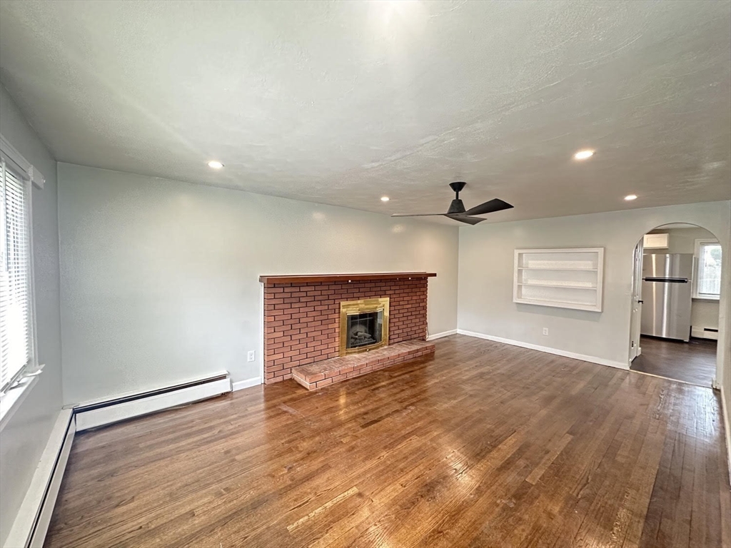 38 Hadley Street Springfield, MA 01118 - Photo 5 of 20 an empty room with windows and fireplace