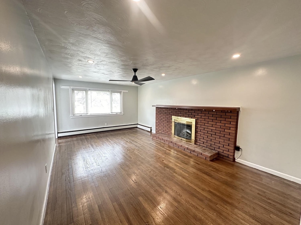 38 Hadley Street Springfield, MA 01118 - Photo 6 of 20 an empty room with wooden floor and windows