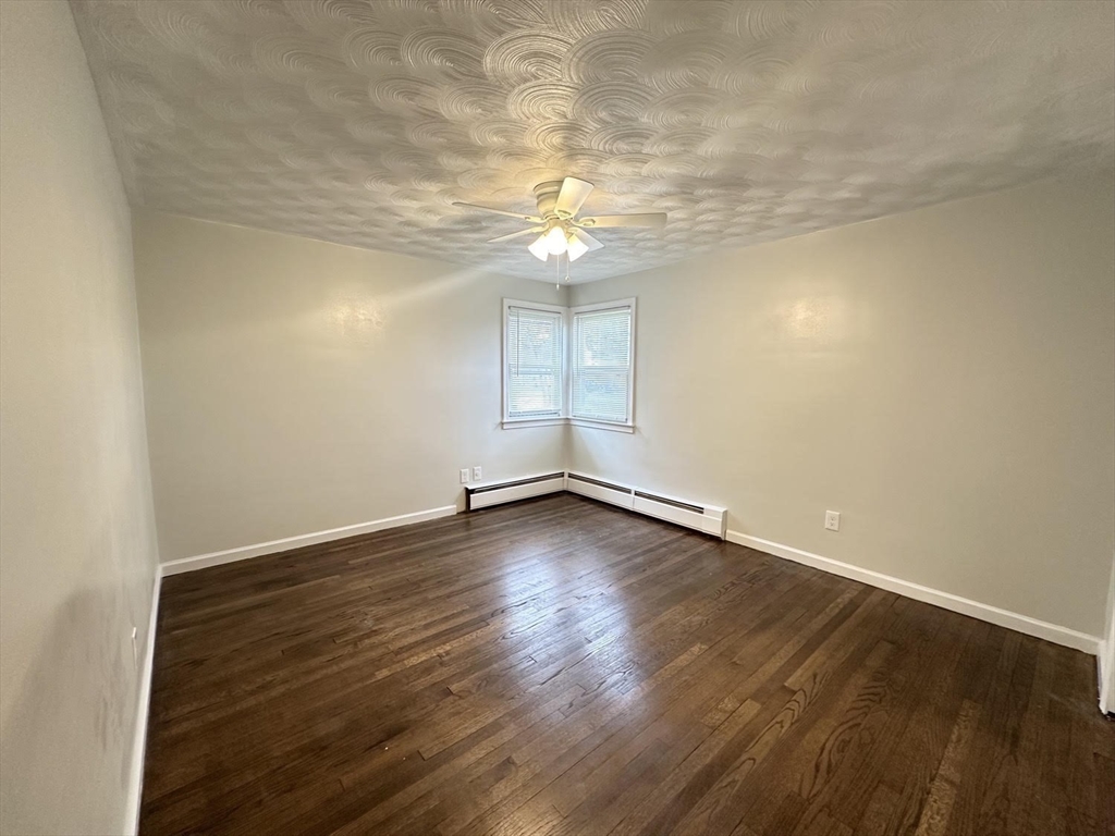 38 Hadley Street Springfield, MA 01118 - Photo 8 of 20 an empty room with wooden floor and windows