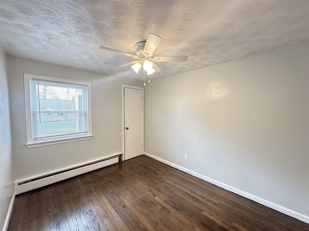 38 Hadley Street Springfield, MA 01118 - Photo 9 of 20 an empty room with wooden floor fan and windows