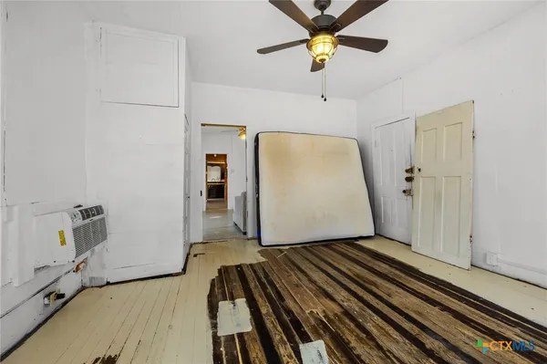 a view of a livingroom with wooden floor and a ceiling fan