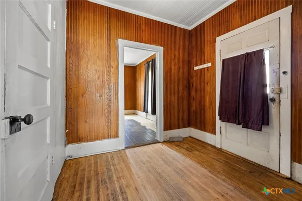 a view of a hallway with wooden floor and closet