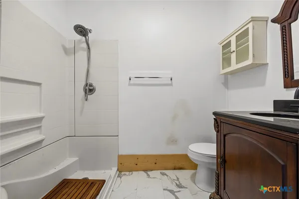 a bathroom with a toilet and a shower