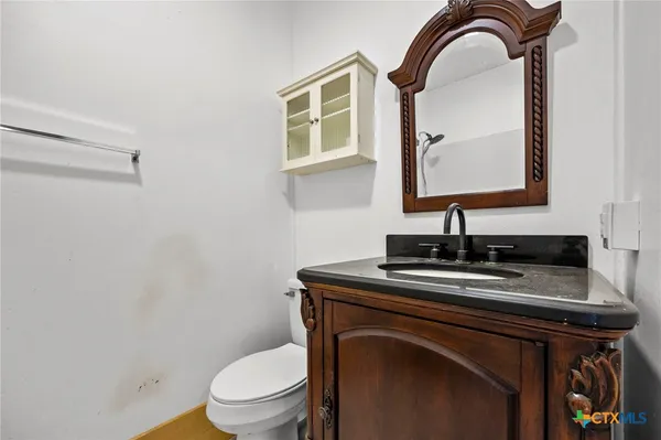 a bathroom with a toilet a sink and mirror
