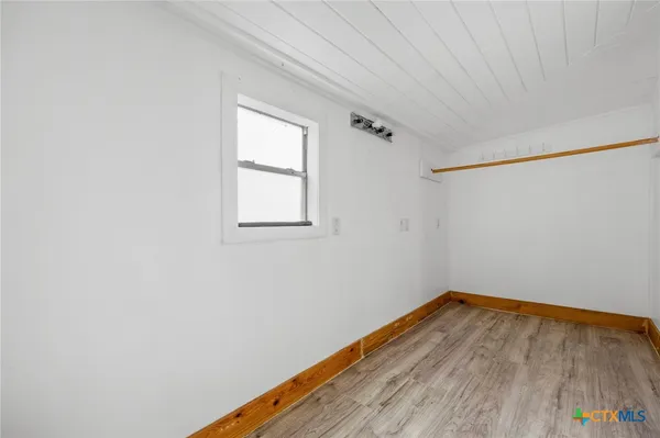 a view of a room with wooden floor and white walls