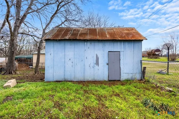 a view of backyard and wooden fence