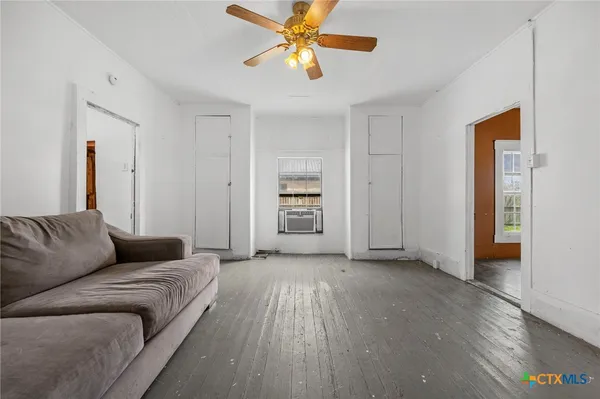 a living room with furniture and a ceiling fan