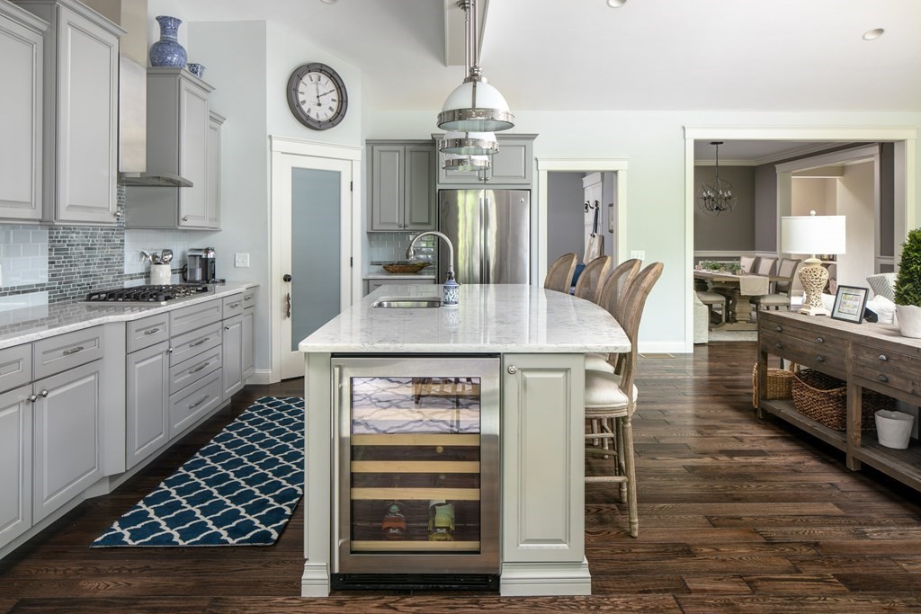 a kitchen with stainless steel appliances kitchen island granite countertop a stove a sink a dining table and chairs