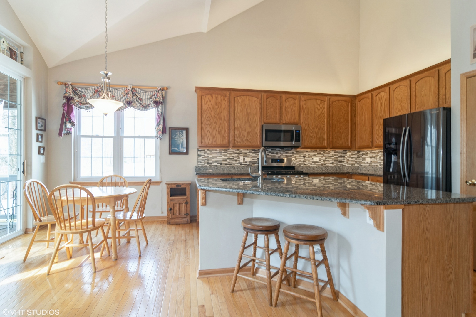 312 Quarry Ridge Circle Sugar Grove, IL 60554 - Photo 7 of 23 a kitchen with stainless steel appliances granite countertop a refrigerator a stove a dining table and chairs with wooden floor