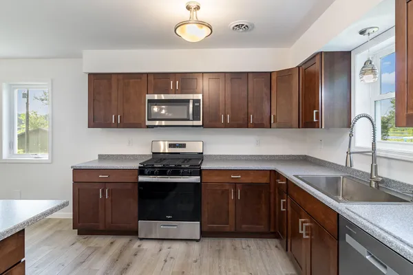a kitchen with sink a microwave and cabinets