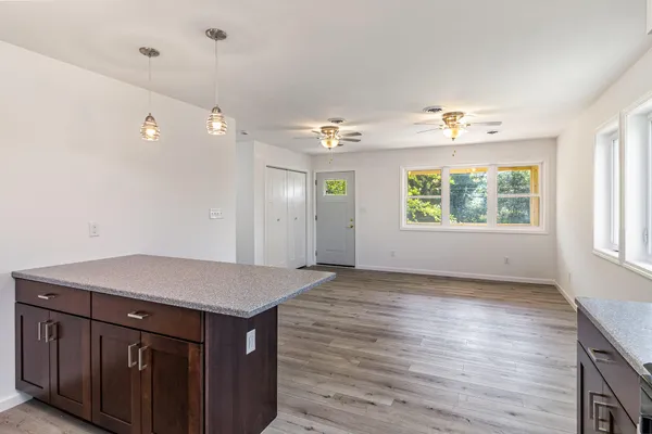 a view of a kitchen with a sink and dishwasher with wooden floor
