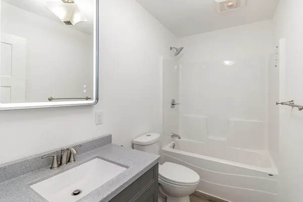 a bathroom with a sink toilet vanity and shower