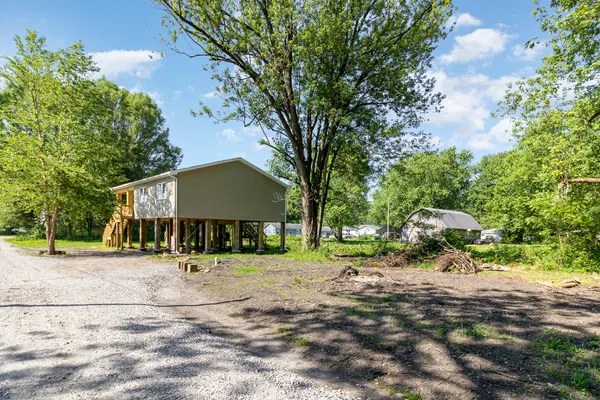 a front view of a house with a yard and trees