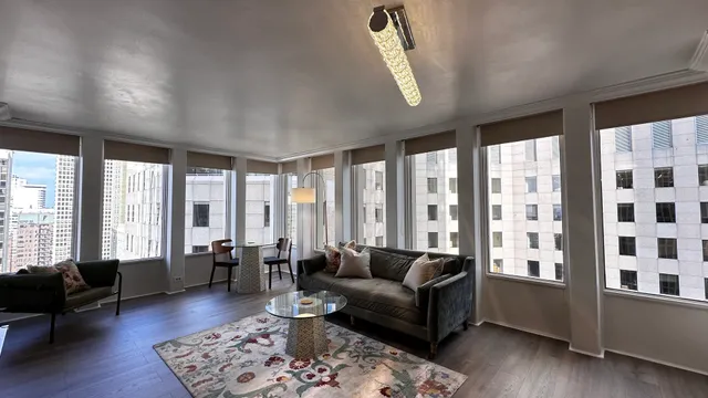 a living room with furniture and floor to ceiling windows