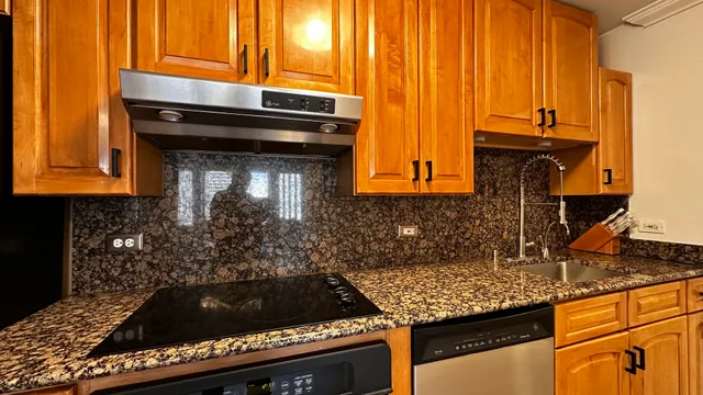 a kitchen with granite countertop a stove and a sink