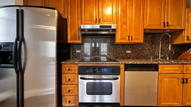 a kitchen with stainless steel appliances granite countertop a refrigerator and a stove