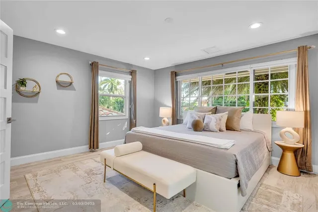 a bedroom with a large bed and wooden floor