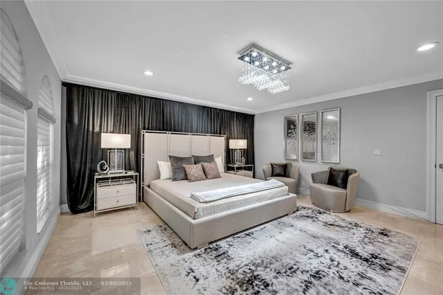 a bedroom with a large bed and a chandelier
