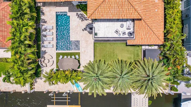 a kitchen with stainless steel appliances kitchen island granite countertop a refrigerator oven a sink dishwasher and white cabinets with wooden floor