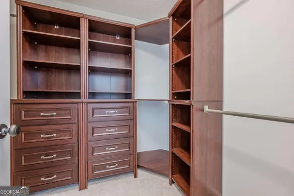 a view of walk in closet with empty racks
