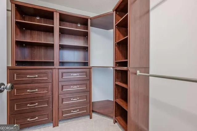 a view of walk in closet with empty racks