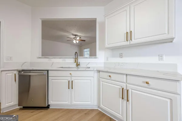 a kitchen with white cabinets and sink