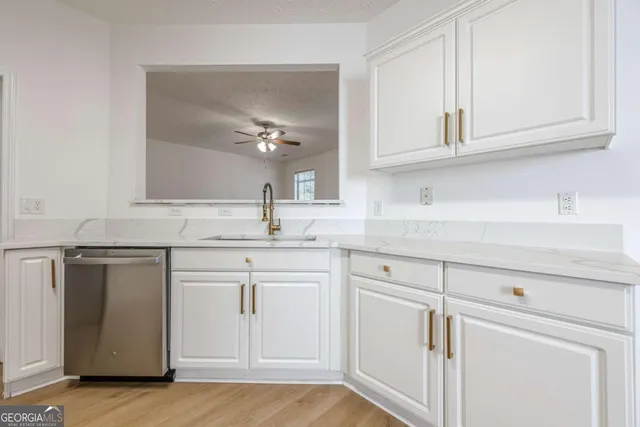 a kitchen with white cabinets and sink