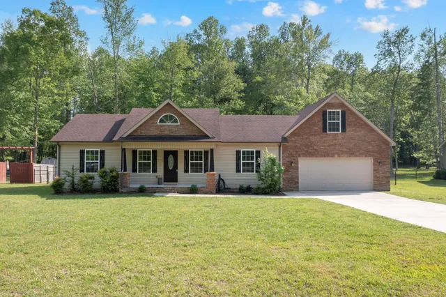 a front view of a house with yard and green space