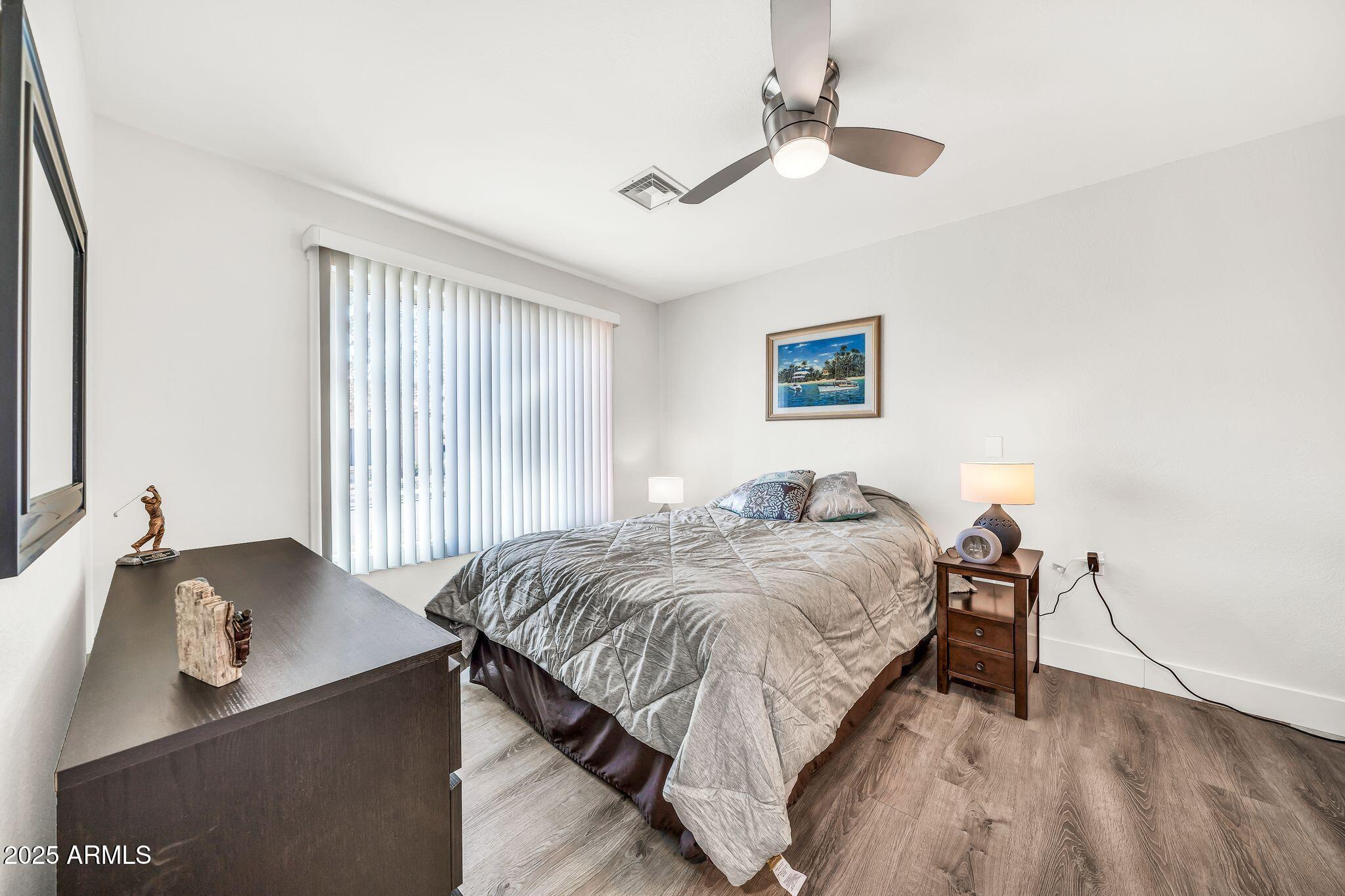 14300 West Bell Road, Unit 423 Surprise, AZ 85374 - Photo 15 of 44 a bed room with a bed and a chandelier