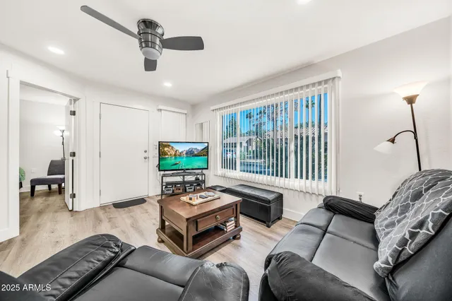 a kitchen with stainless steel appliances granite countertop a dining table chairs refrigerator and microwave