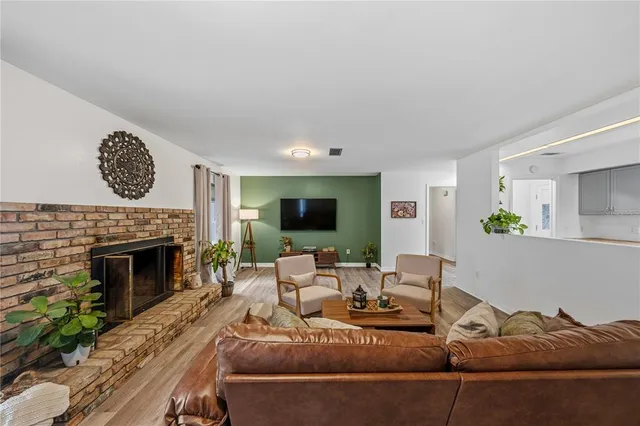 a view of a hallway with wooden floor and a bathroom