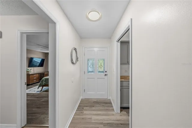 an empty room with wooden floor a ceiling fan and windows