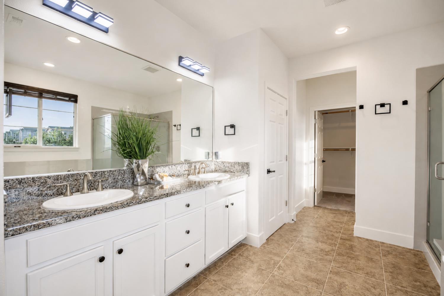 1837 South La Barbera Avenue Mountain House, CA 95391 - Photo 24 of 54 a spacious bathroom with a granite countertop sink a mirror and a