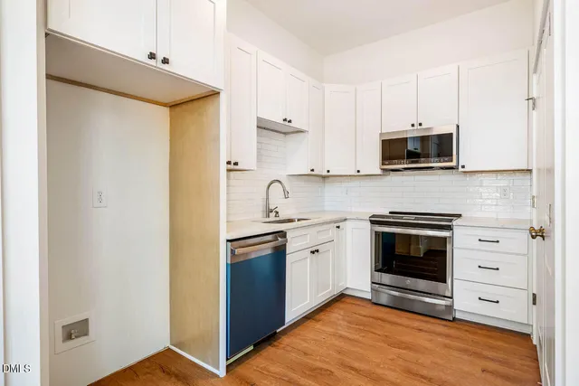 a kitchen with stainless steel appliances granite countertop a stove top oven a sink and a microwave