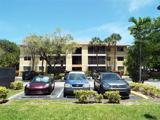 a front view of a house with a garden and trees