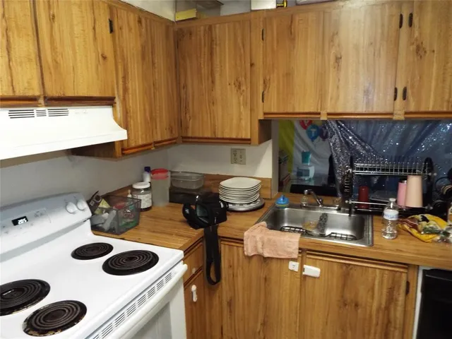 a kitchen with a stove and a wooden cabinets