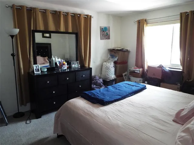 a bedroom with a bed window and mirror