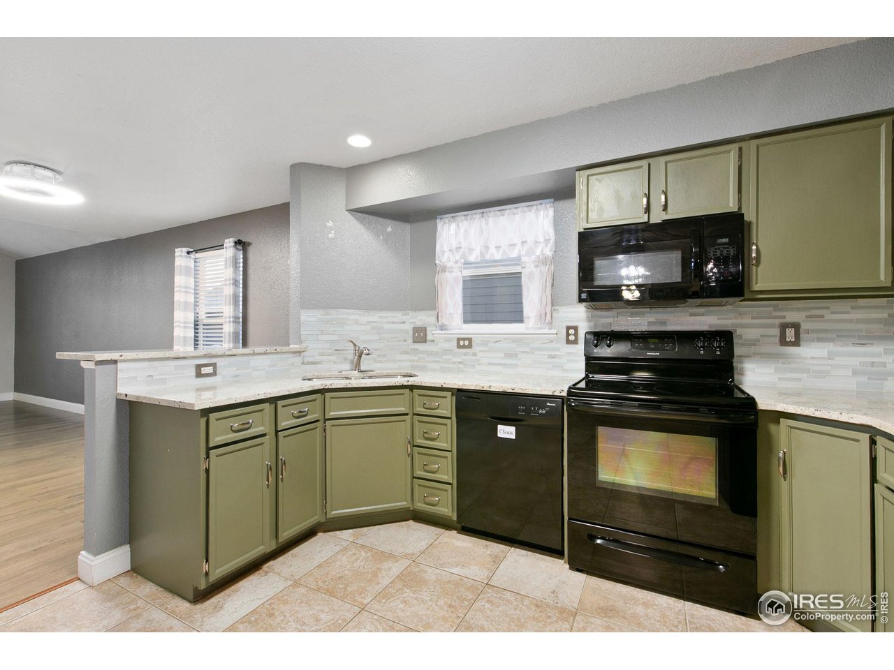 3217 Baldwin Avenue Evans, CO 80620 - Photo 10 of 28 a kitchen with stainless steel appliances granite countertop a stove a sink and a microwave