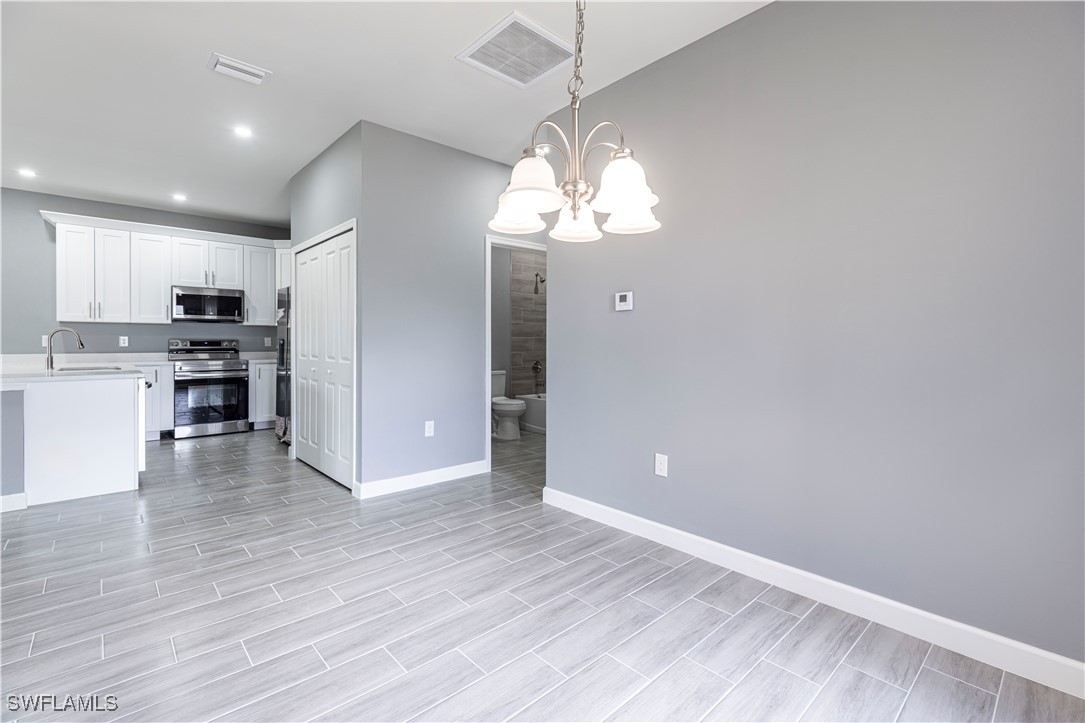2422 Mae Avenue South Lehigh Acres, FL 33973 - Photo 11 of 28 a view of a kitchen with a sink and dishwasher a refrigerator with wooden floor